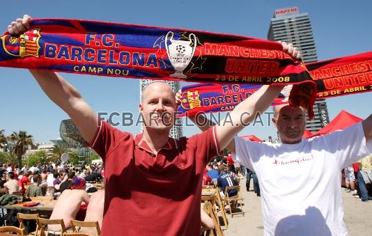 Dos aficionados visitantes muestran la bufanda del partido.