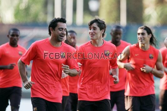 Xavi y Bojan, en primer plano, conversando.