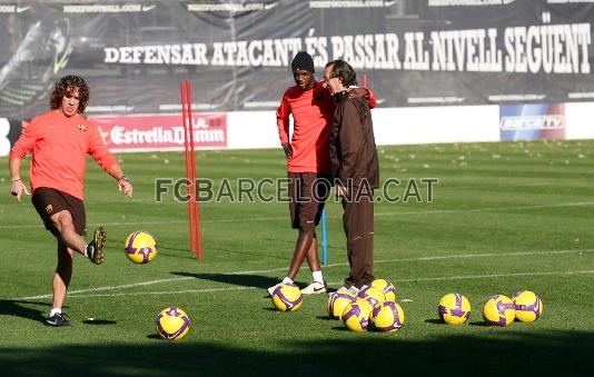 Puyol chutando, mientras que Tour escucha lo que le dice Paco Seirullo.