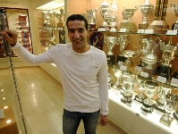 Juan Carlos Lpez, al lado de los trofeos de algunas de las secciones profesionales del club