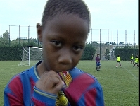 Imatge del migcampista de Granollers del Benjam A Mamadou Traor que celebra un dels gols del seu equip amb un pet a l'escut blaugrana.