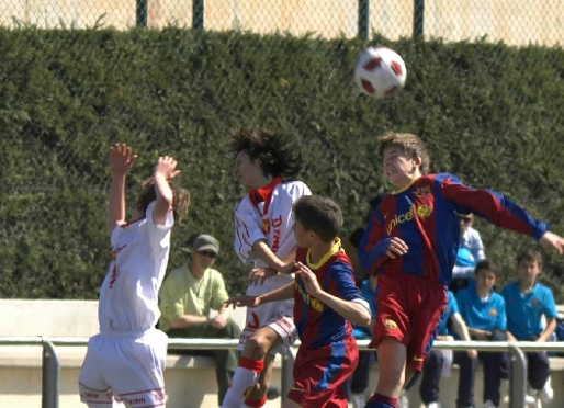 Els jugadors de l'Infantil B i de la Damm lluiten per rematar una pilota en el partit d'aquest dissabte. Fotos: Severino Fernndez i Arxiu FCB